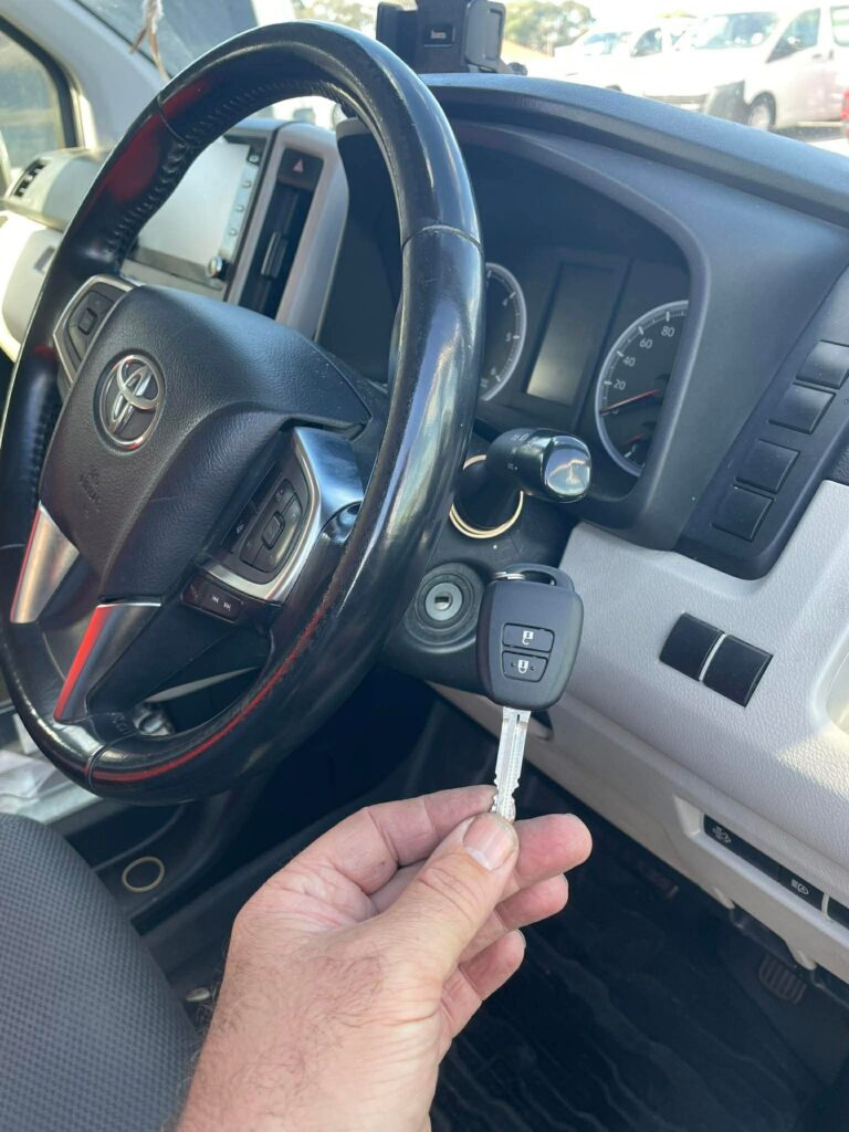 New Toyota transponder key held at the ignition of a Toyota HiAce van